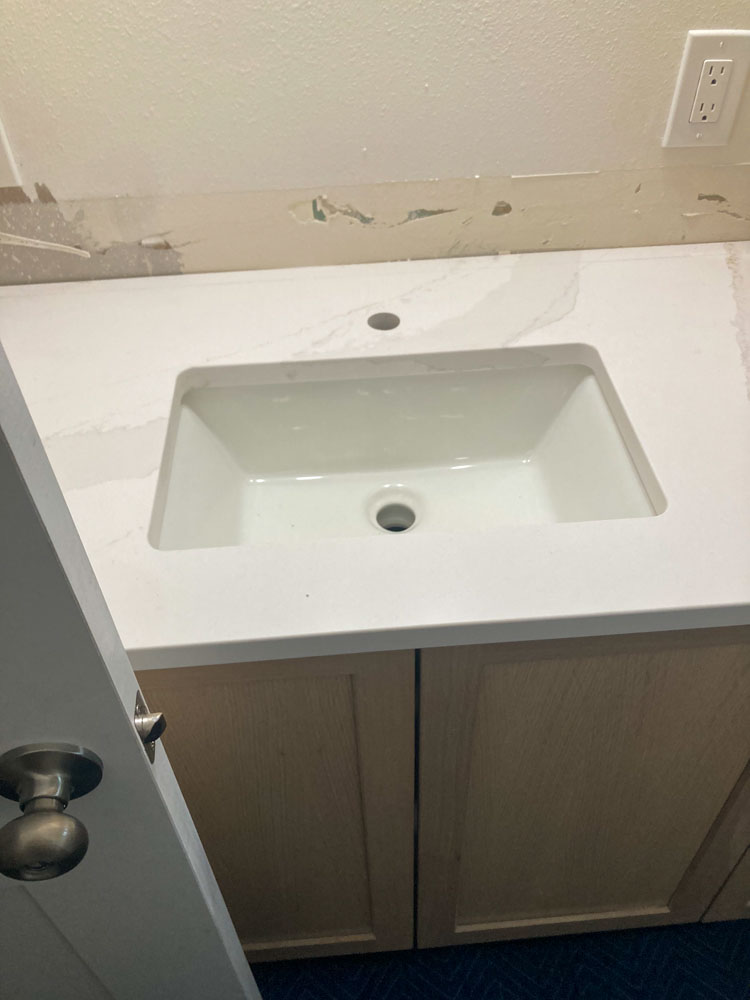 Installing faucet with thermostat. Man's hands are fixing bath tap into place.